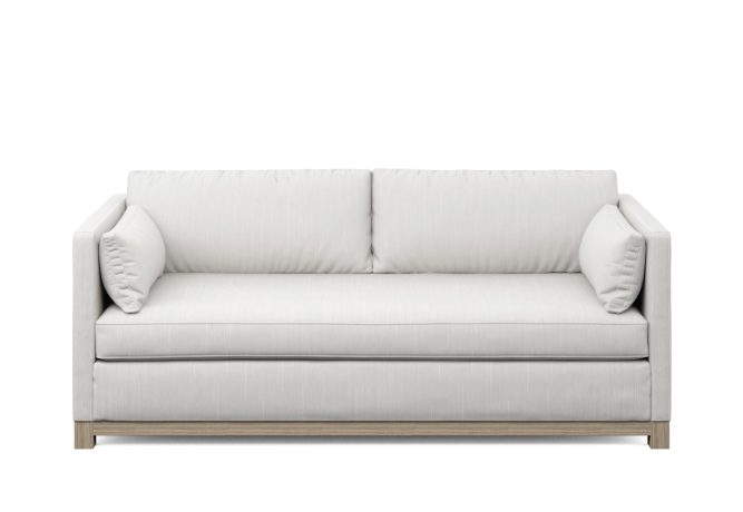 modern white condo sofa with wood base and two pillows