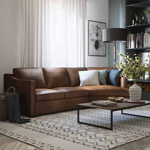 brown leather sectional with blue pillows